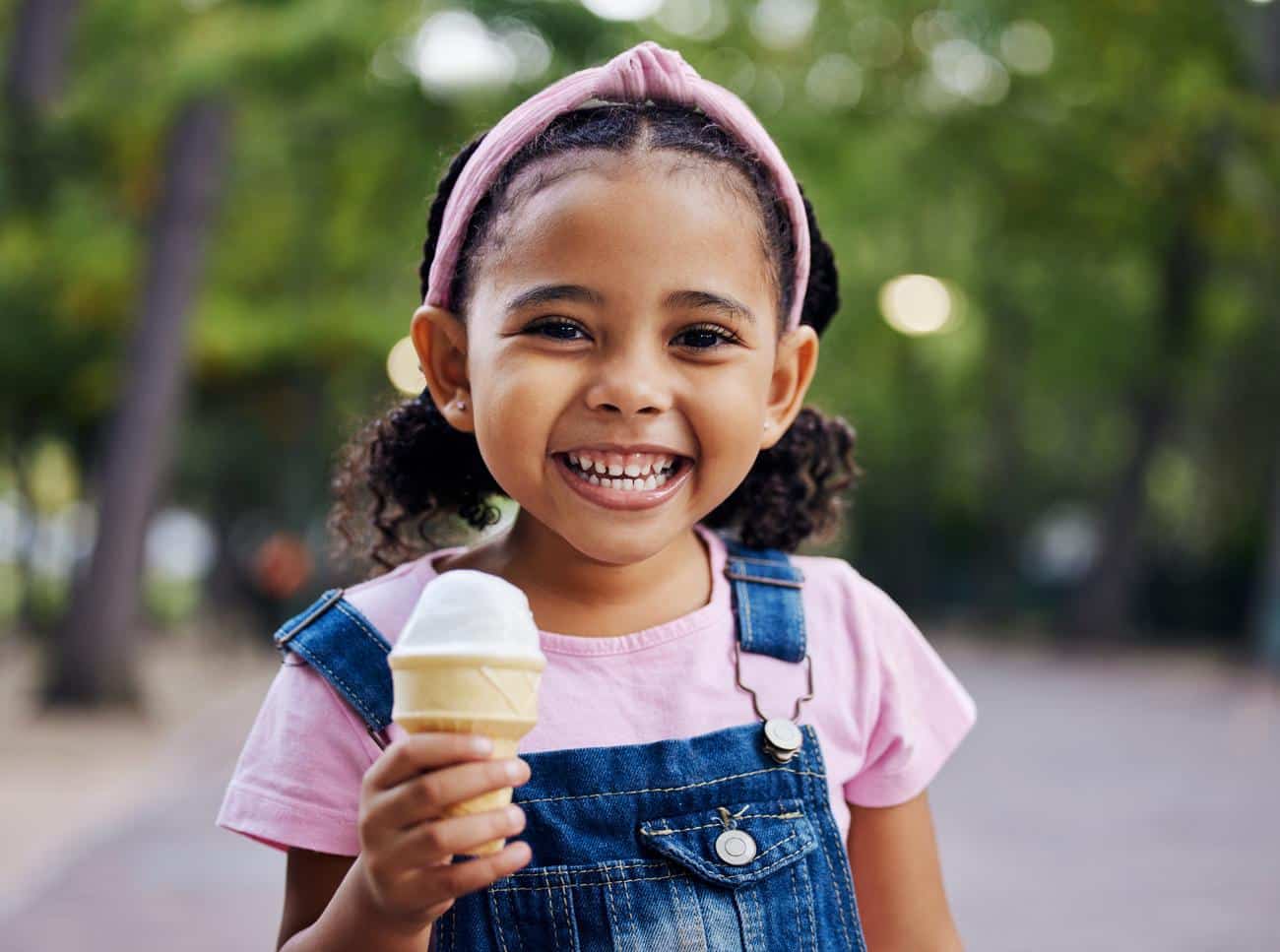 Young-girl-smiling-eating-ice-cream-outside Pediatric health care pediatrics