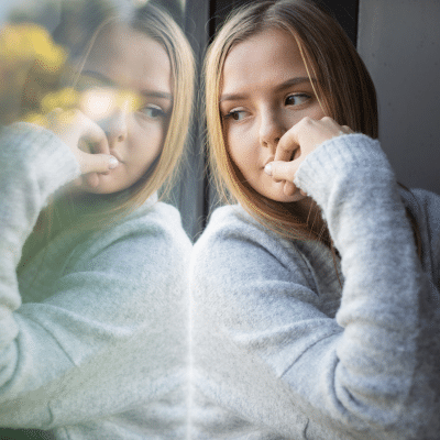 Girl with chronic medical condition looking out the window