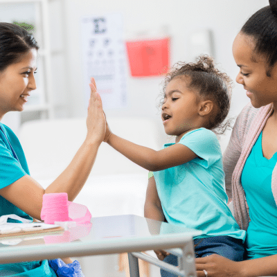 Little girl giving pediatric doctor high five, representing advanced pediatric care