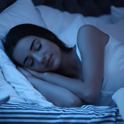 A woman sleeping in bed, representing sleep hygiene