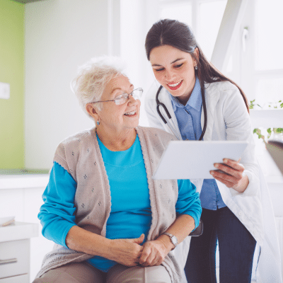 An internist meeting with an older patient about test results on a tablet, representing internal medicine vs primary care